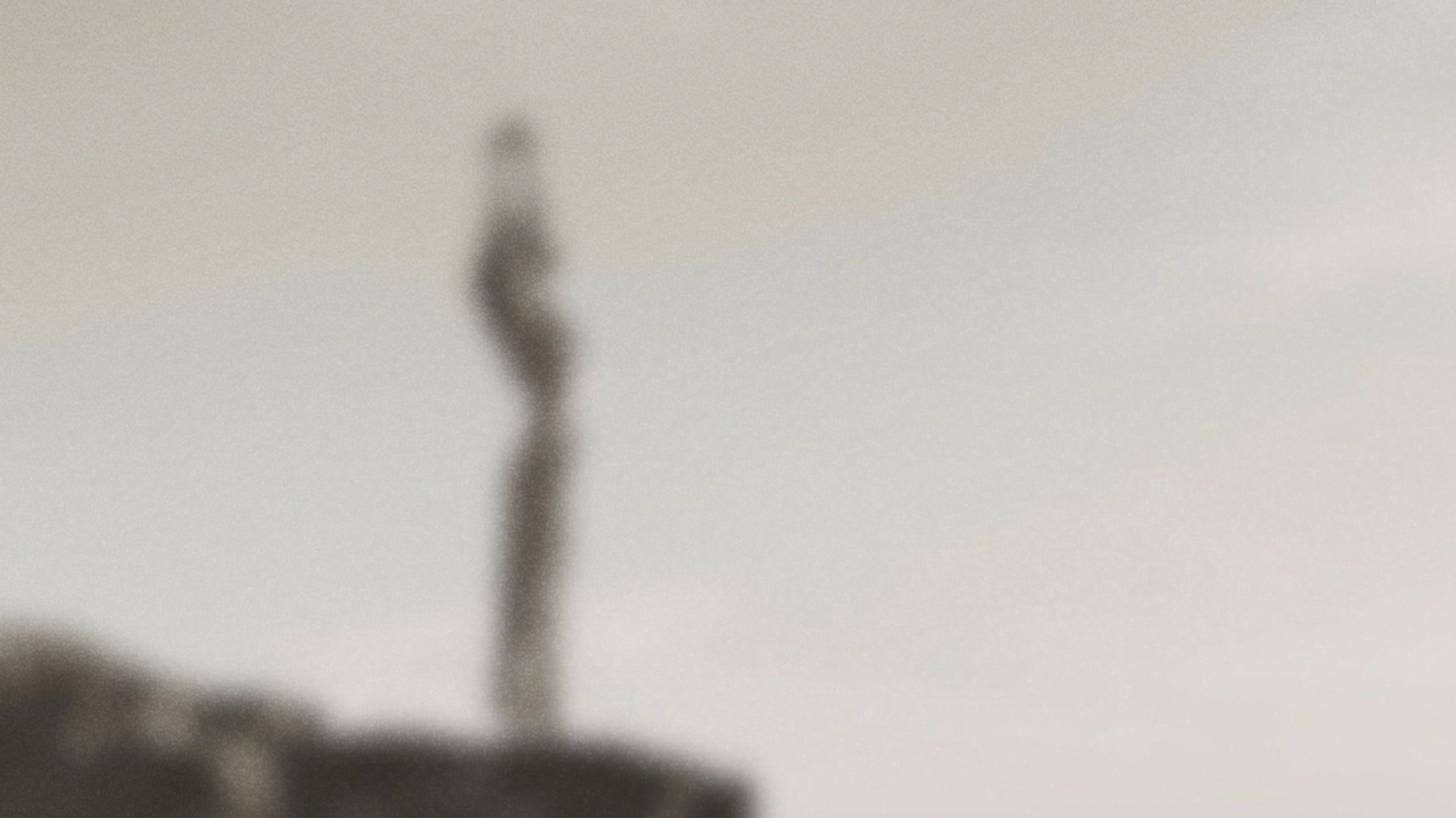 Blurred image of a a girl posing atop a vista